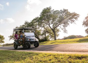 family riding in golf car on a sunny evening